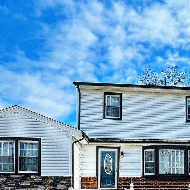 White-sided home with dark gutter and roofline detail