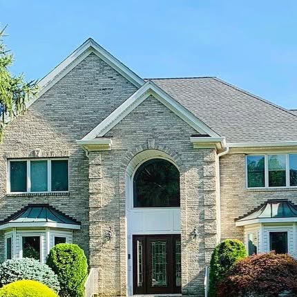 Stone home with a completed roofline and gutters